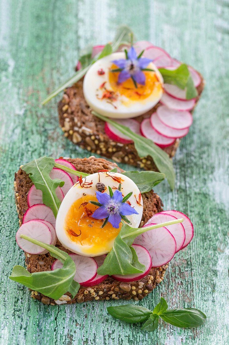 Slices of wholemeal bread topped with radish, egg and borage flowers