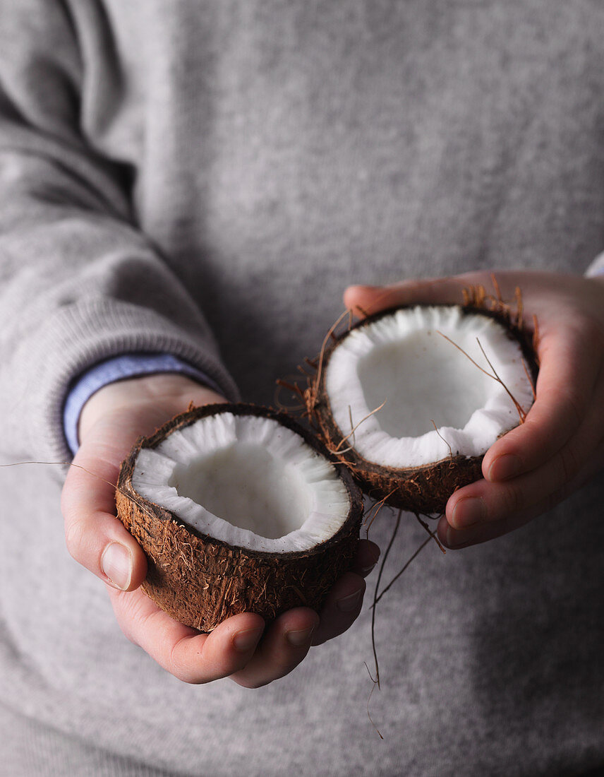 A person holding a coconut