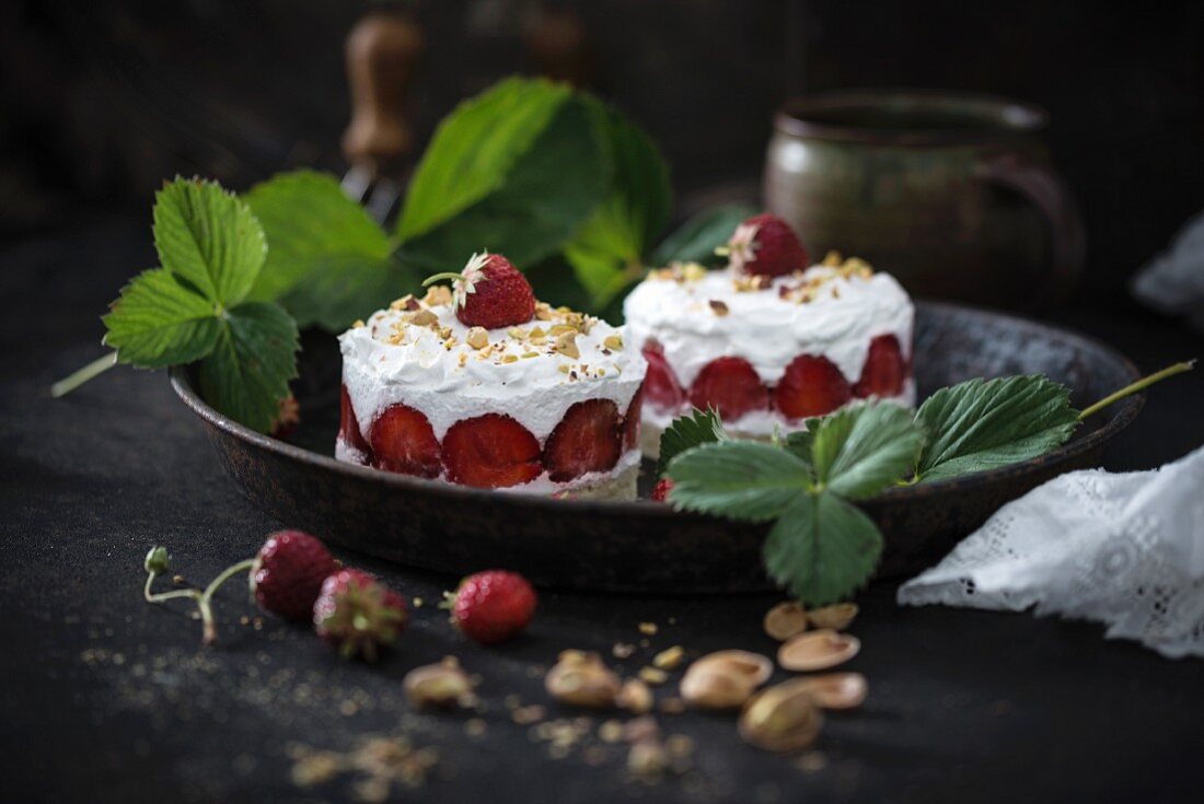 Vegan strawberry cakes with whipped soya cream and pistachios