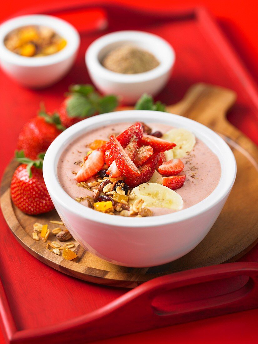 A strawberry smoothie bowl with banana and nuts