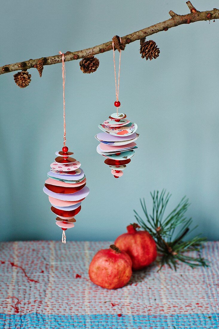 Baubles made from paper circles and beads hung from larch branch