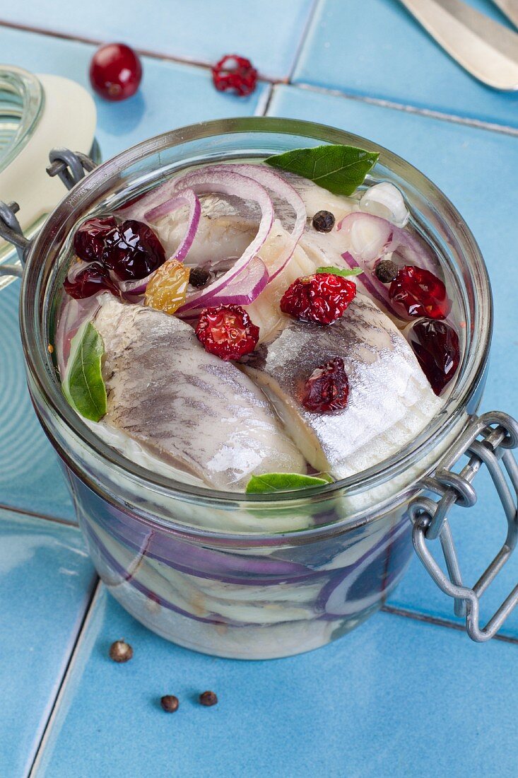 Marinated herring fillets with cranberries and raisins in a jar