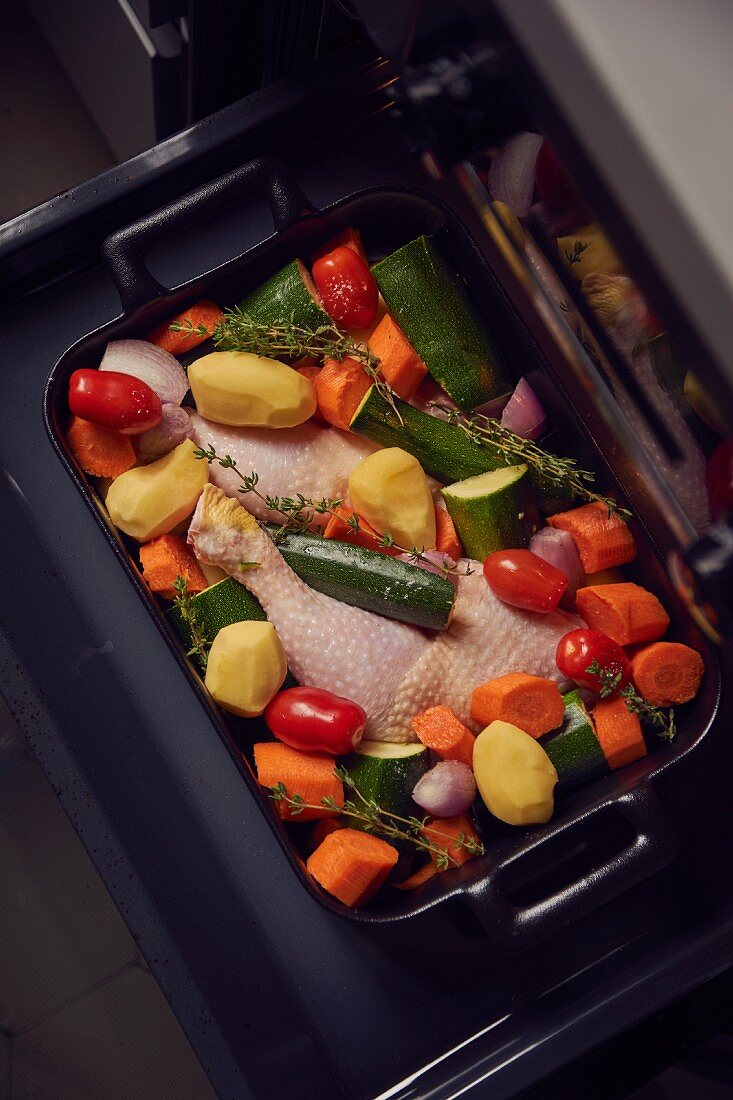 Chicken legs with vegetables on a baking tray
