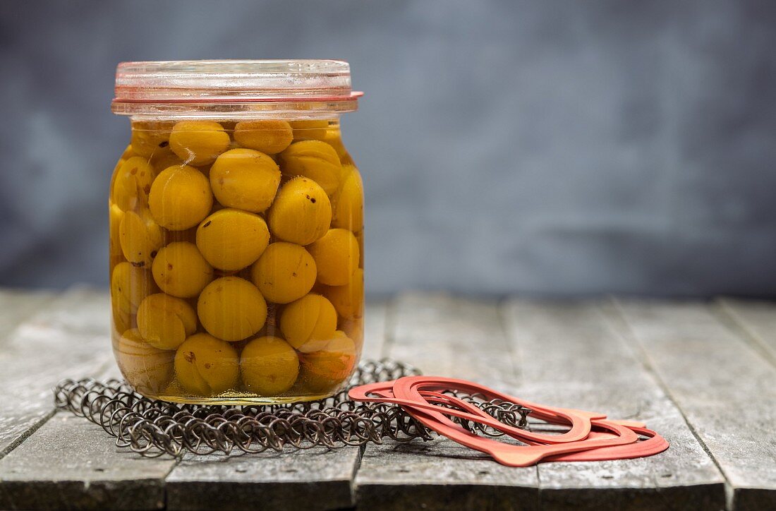 Preserved small yellow plums in a glass jar