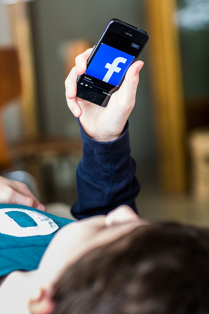 Teenage boy using Facebook on a Smartphone
