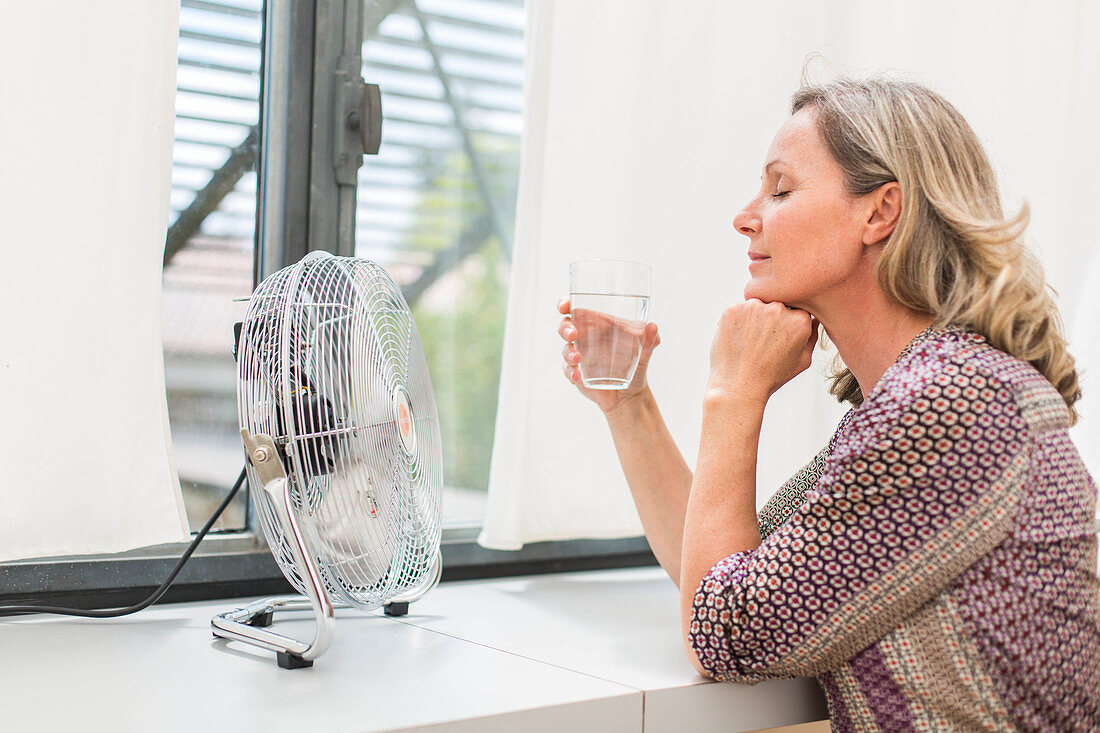 Woman using an electric fan