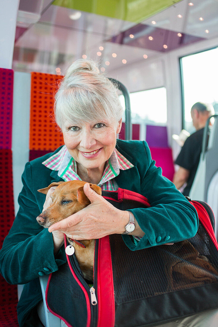 Senior woman on a train with her dog