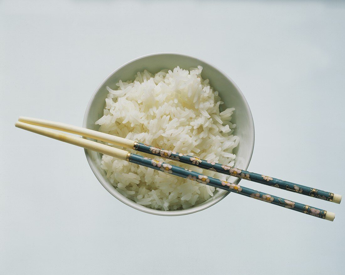 Cooked White Rice in Bowl with Chop Sticks