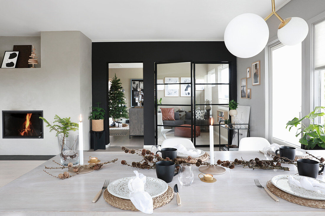 Festively set table and fireplace in bright interior