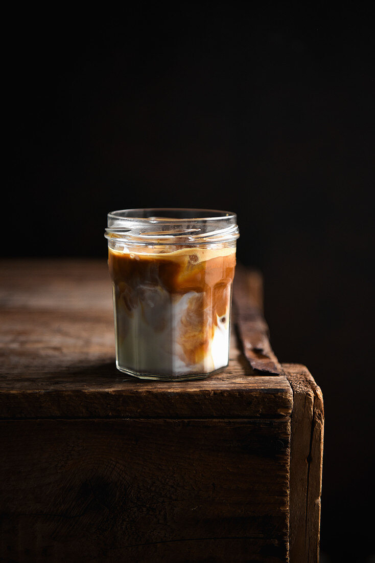 Dark Iced Latte in a jar on a wooden table
