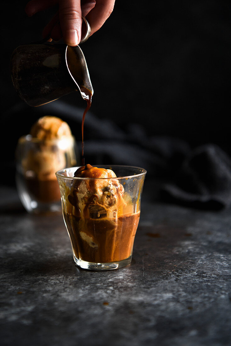 Sauce fließt auf Affogato mit Karamellleis (Italien)