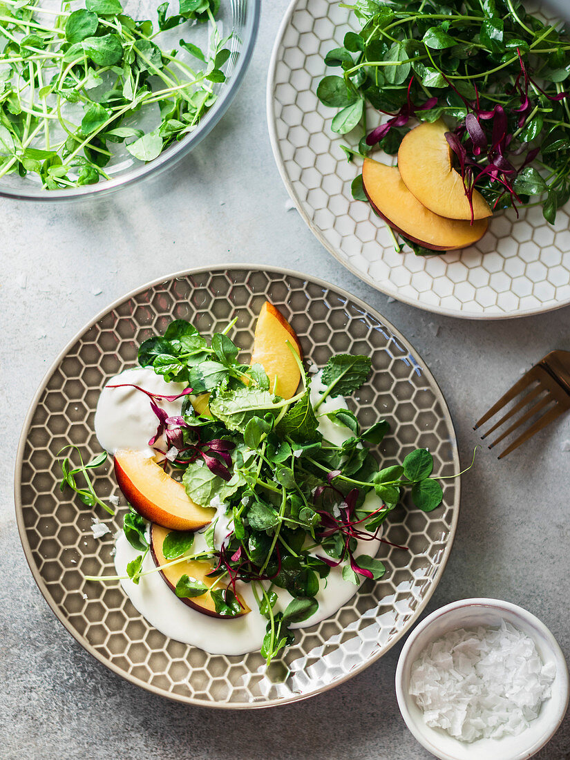 Ricotta salad with peaches and microgreens served on the gray plate