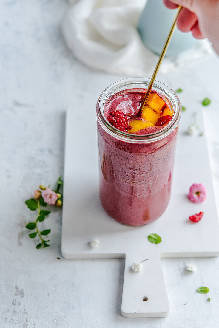 Raspberry-mango smoothie in a jar