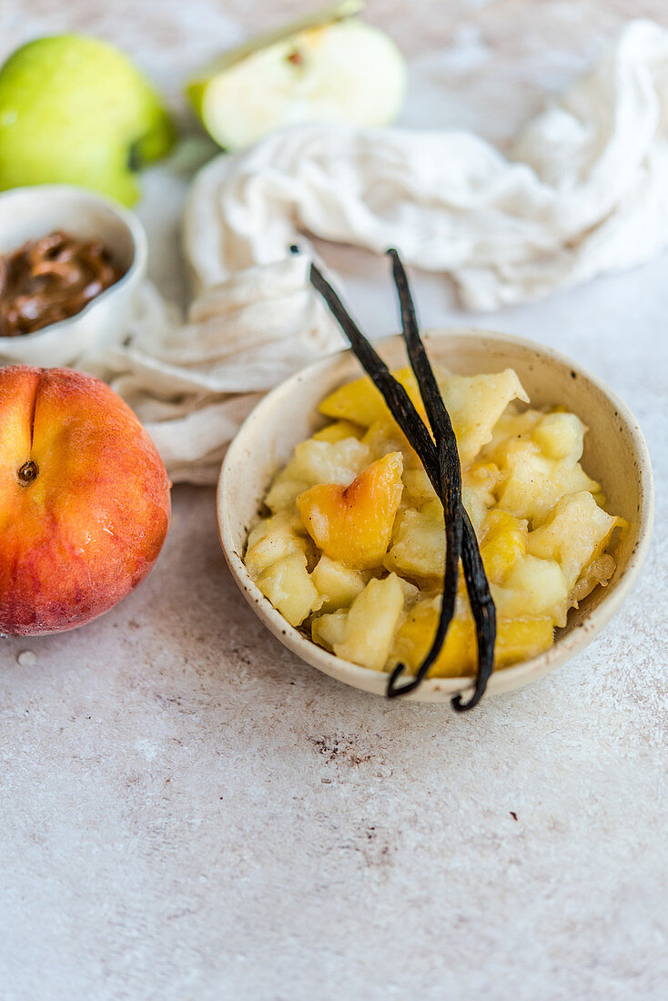 Apples stewed with peaches and vanilla in a bowl