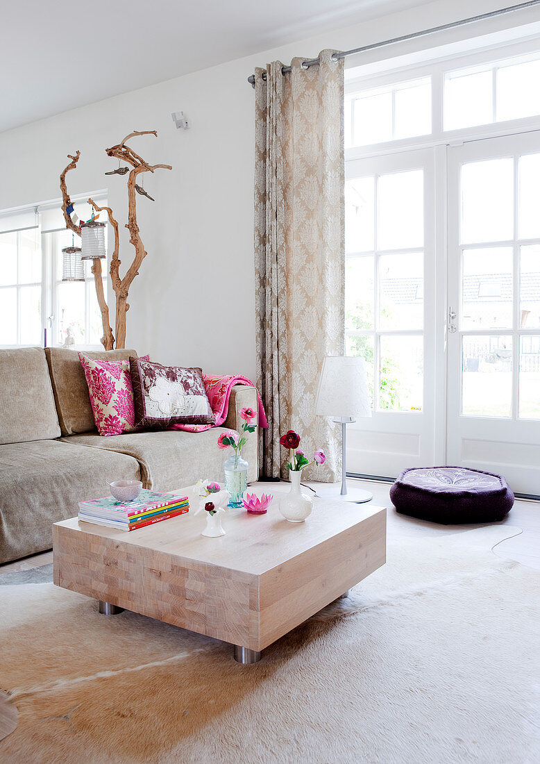 Coffee table made from solid block of wood on cowhide rug in living room