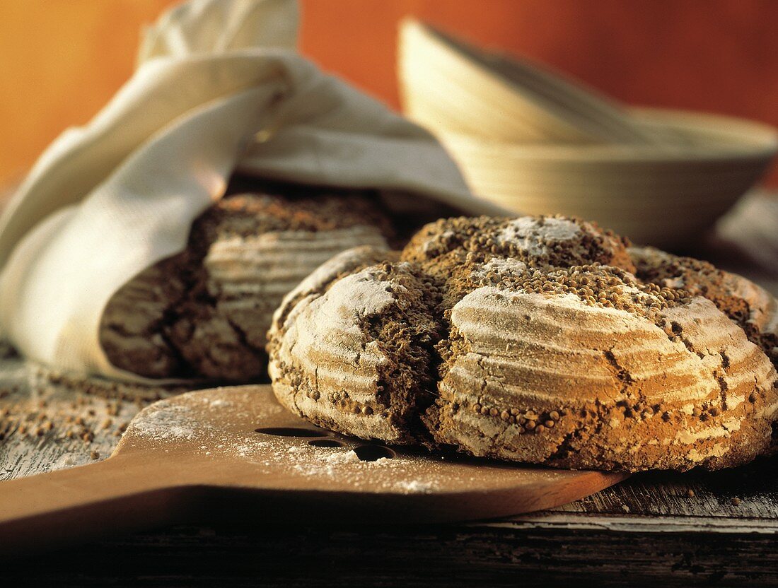 Two Loaves of Coriander Bread on Wooden Table