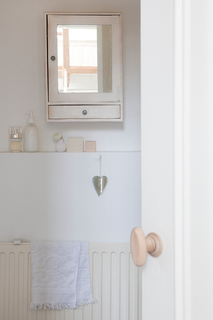 View of wall cabinet in white bathroom