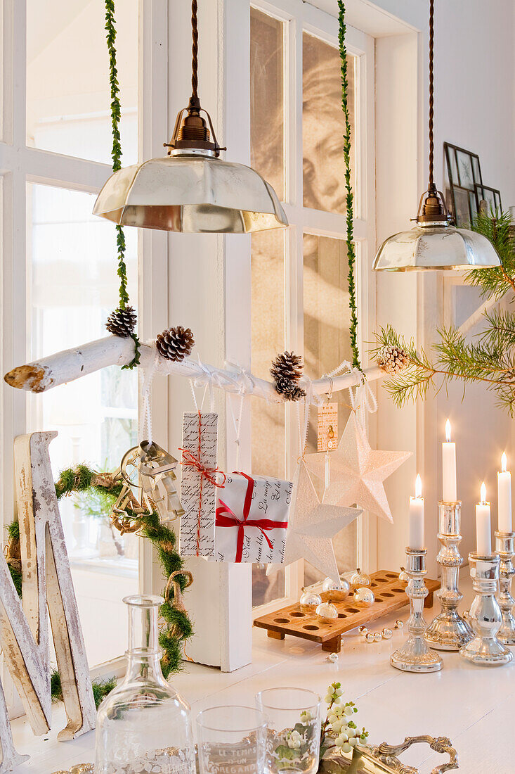 Branch with Christmas decorations hung over the table