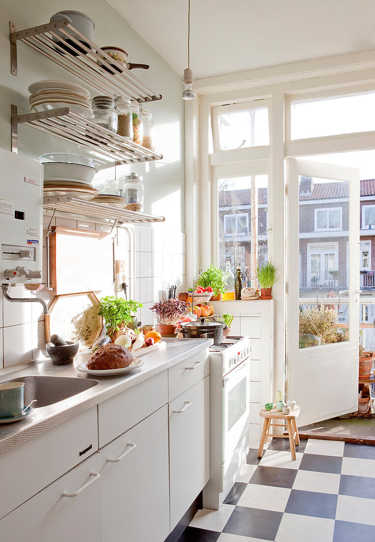 White kitchen with chequered floor and balcony doors