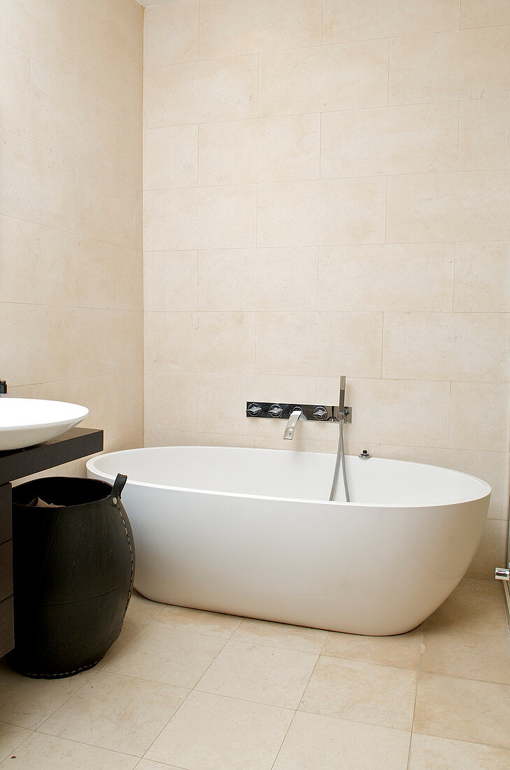 Oval freestanding bathtub in the modern bathroom in light beige