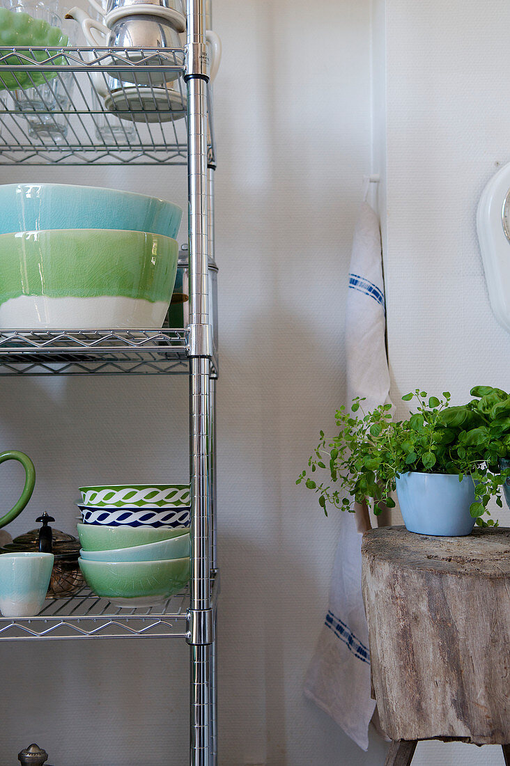 Green and blue crockery on metal shelves