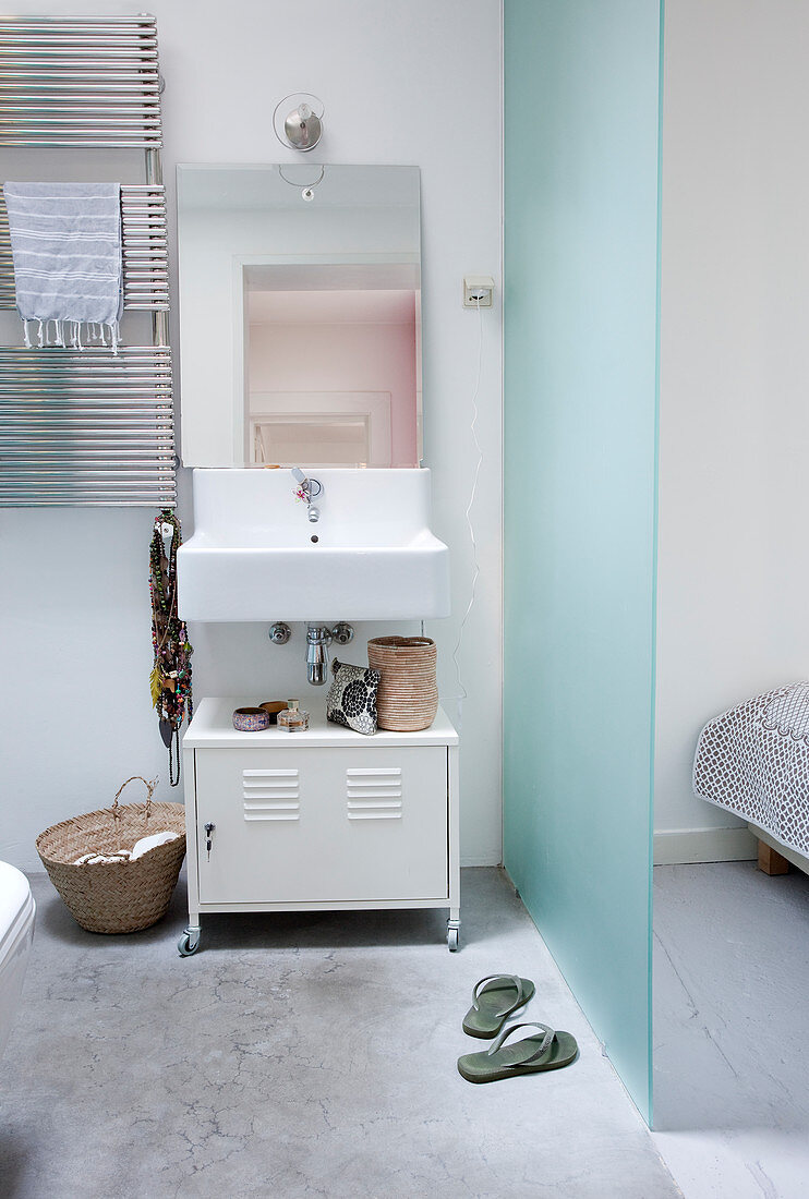 Sink above white metal cabinet in ensuite bathroom