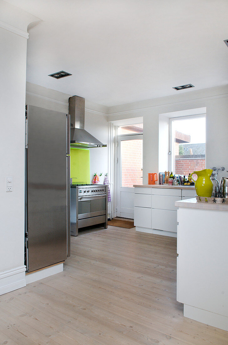 Modern kitchen with light wood floors and stainless steel appliances