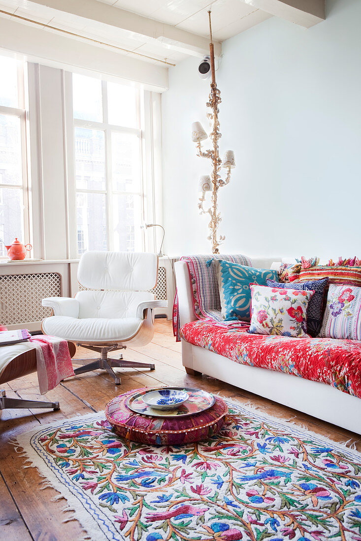 Colourful accessories and classic Eames Lounge Chair in living room of period building