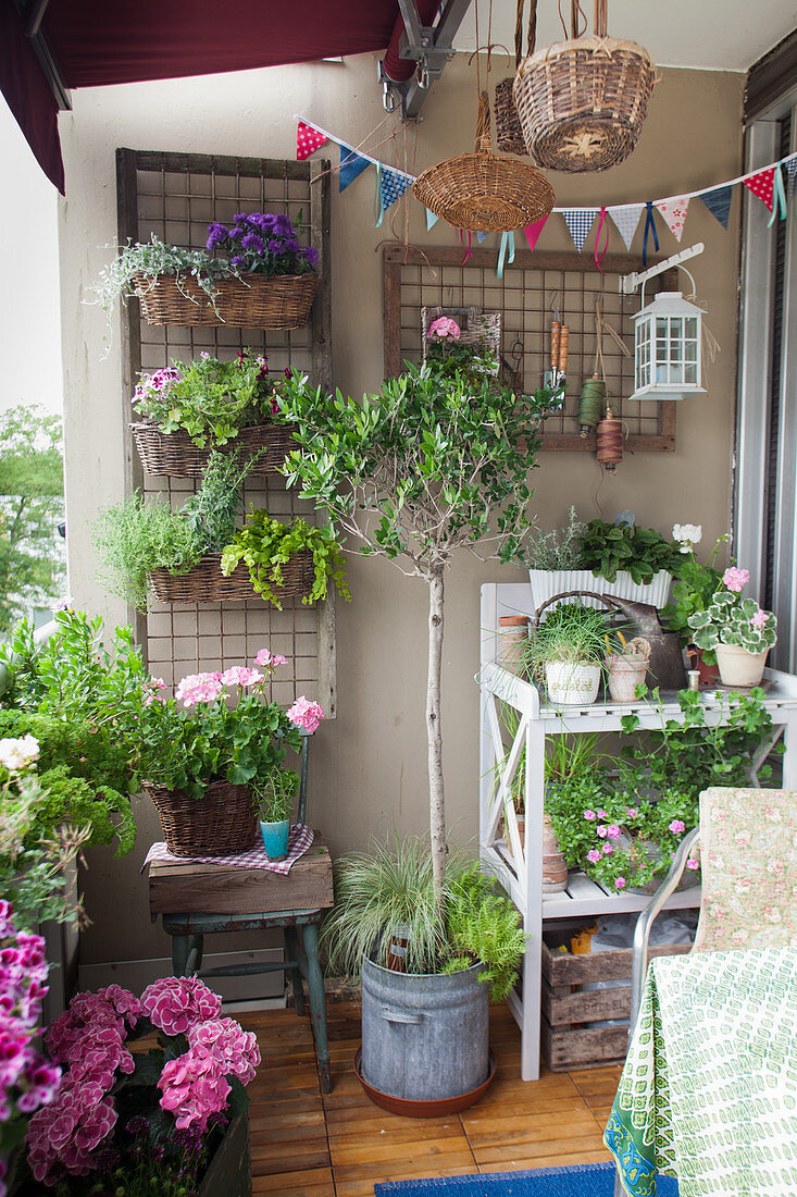Lush greenery, summery flowers and potting bench on balcony