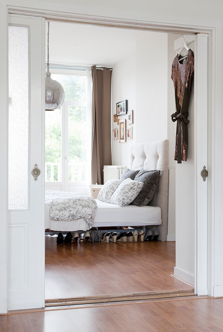 Blick durch geöffnete Schiebetüren in Schlafzimmer, Damenschuhe unter dem Bett