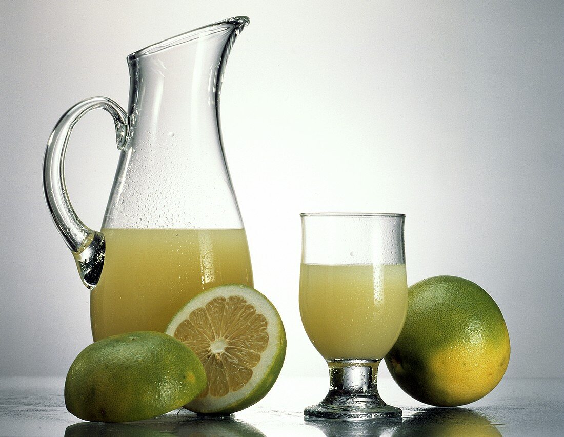 Grapefruitsaft in Glas & Karaffe, Deko: frische Grapefruits