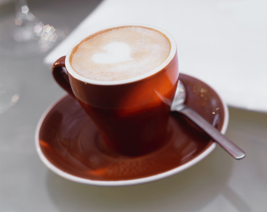 Cappuccino in brauner Tasse mit Kaffelöffel