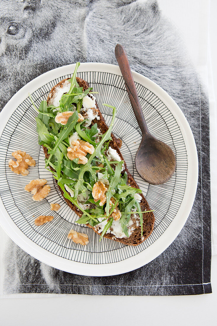 Slice of bread with arugula and walnuts