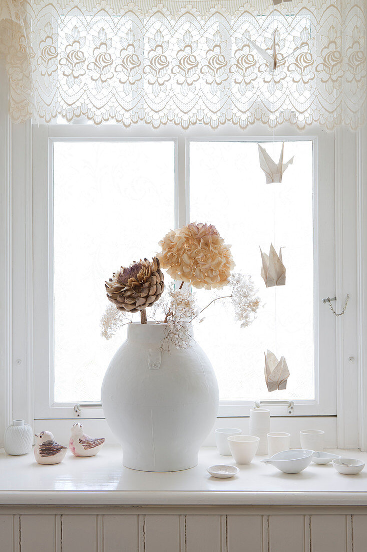 Vase of dried flowers on a windowsill