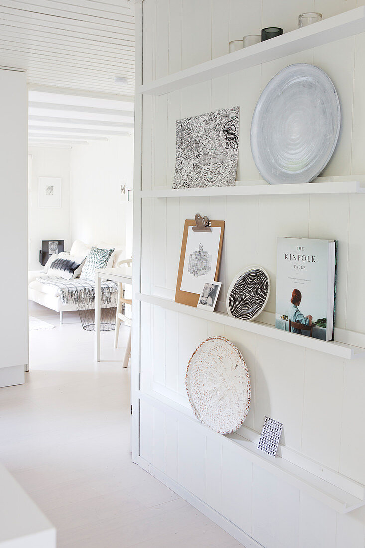 Shelves with decorative plates on a white wooden wall