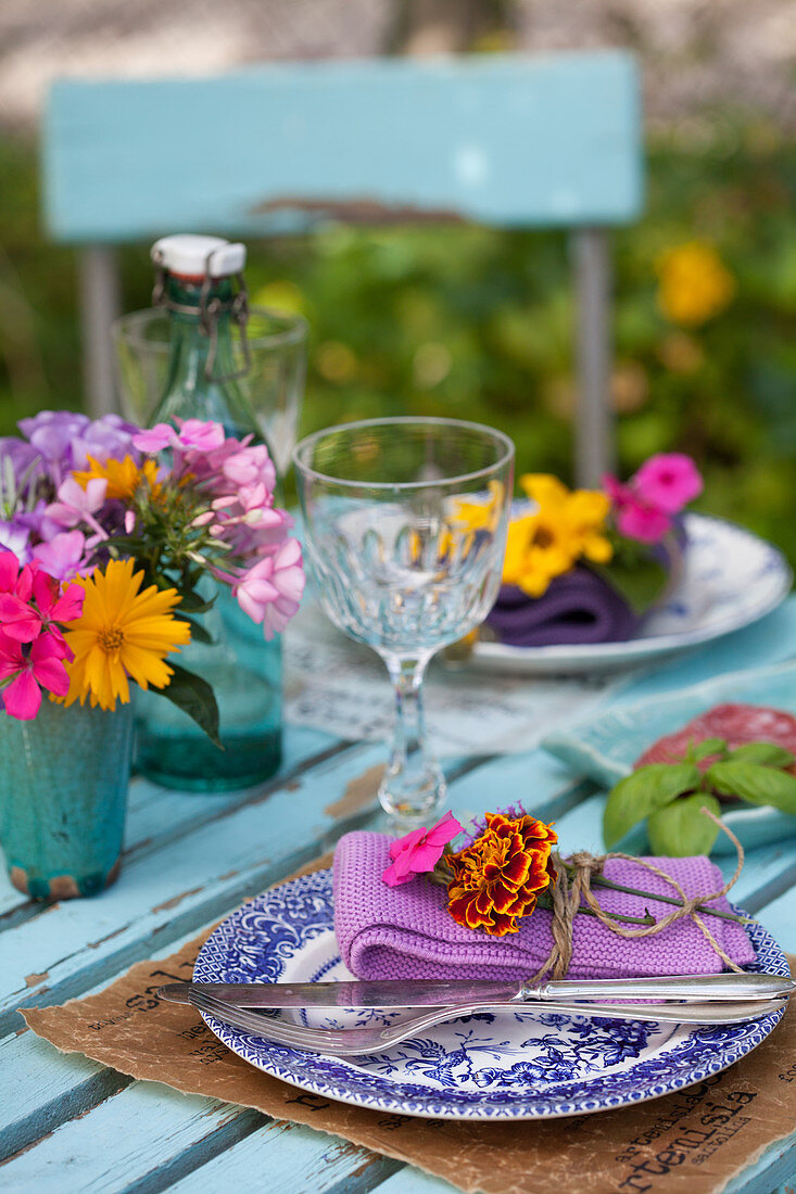 Set table decorated with summer flowers in garden