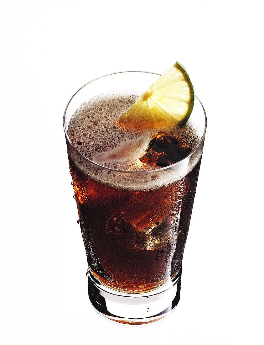 Bacardi and coke with ice cubes and lemon wedge in glass