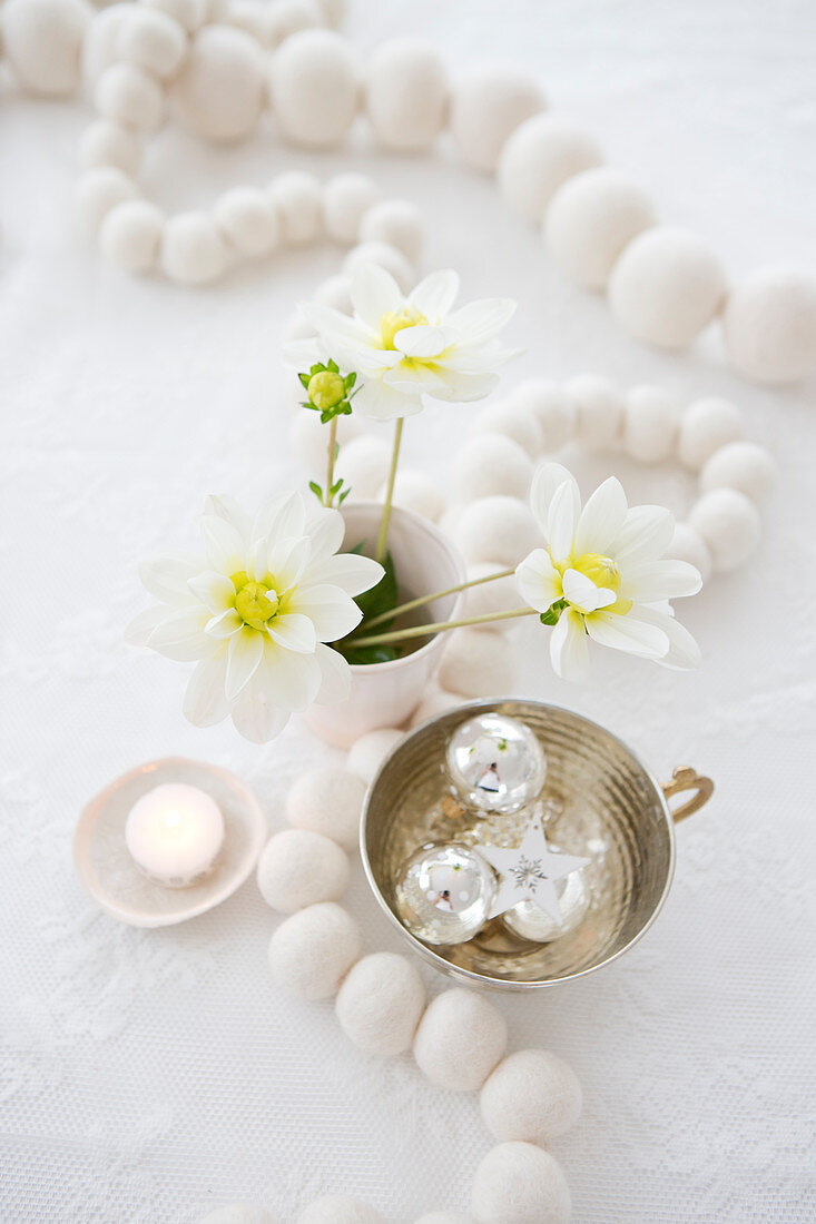 Weiße Holzperlenkette, Blume und Baumschmuck auf Weihnachtstisch