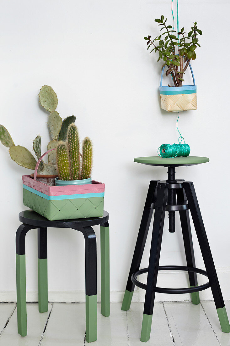 Black and green painted stools and baskets as planters