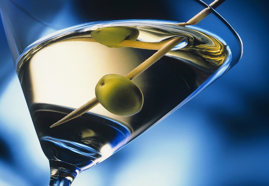 Ein Glas Martini dry mit Olive auf Holzspiess