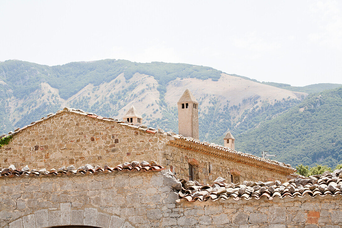 Natural stone building with towers in front of mountain landscape, Sicily, Italy