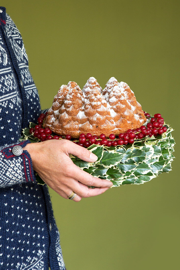 Weihnachtlicher Kuchen dekoriert mit Ilex und Johannisbeeren