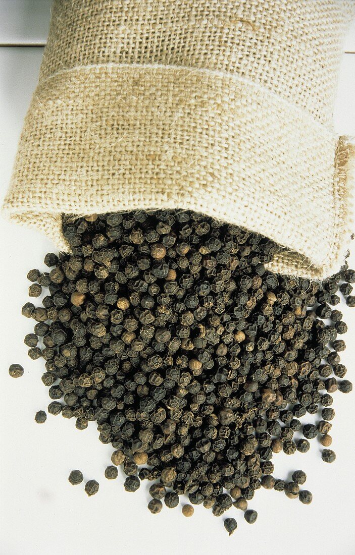 Black Peppercorns Spilling From a Burlap Bag