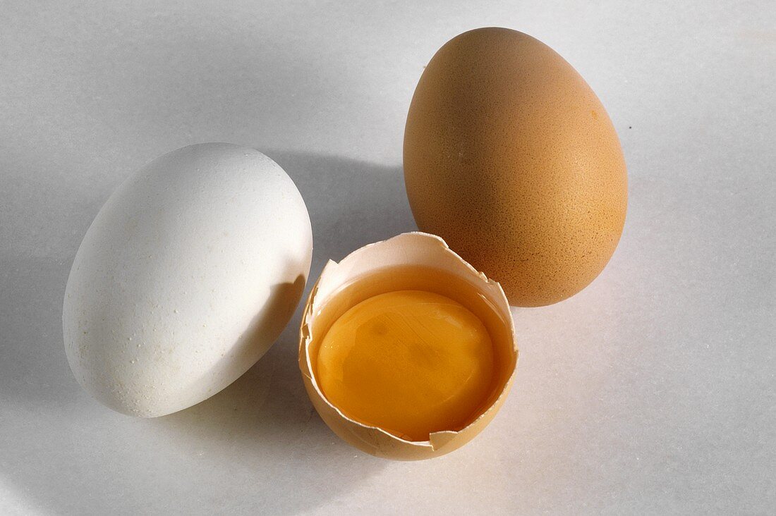 Weißes & braunes Ei & ein aufgeschlagenes halbes Ei