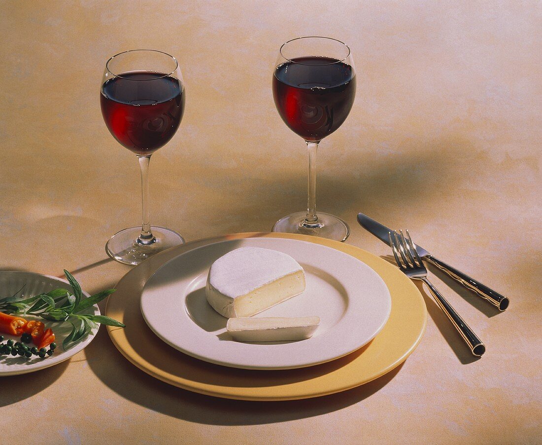 Camembert Cheese on a Plate with Two Glasses of Red Wine