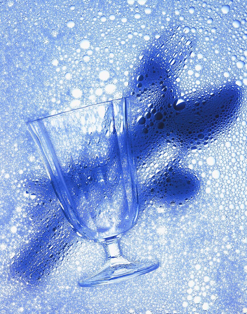 Glas & Schatten eines Besteckes auf blauem Schaum