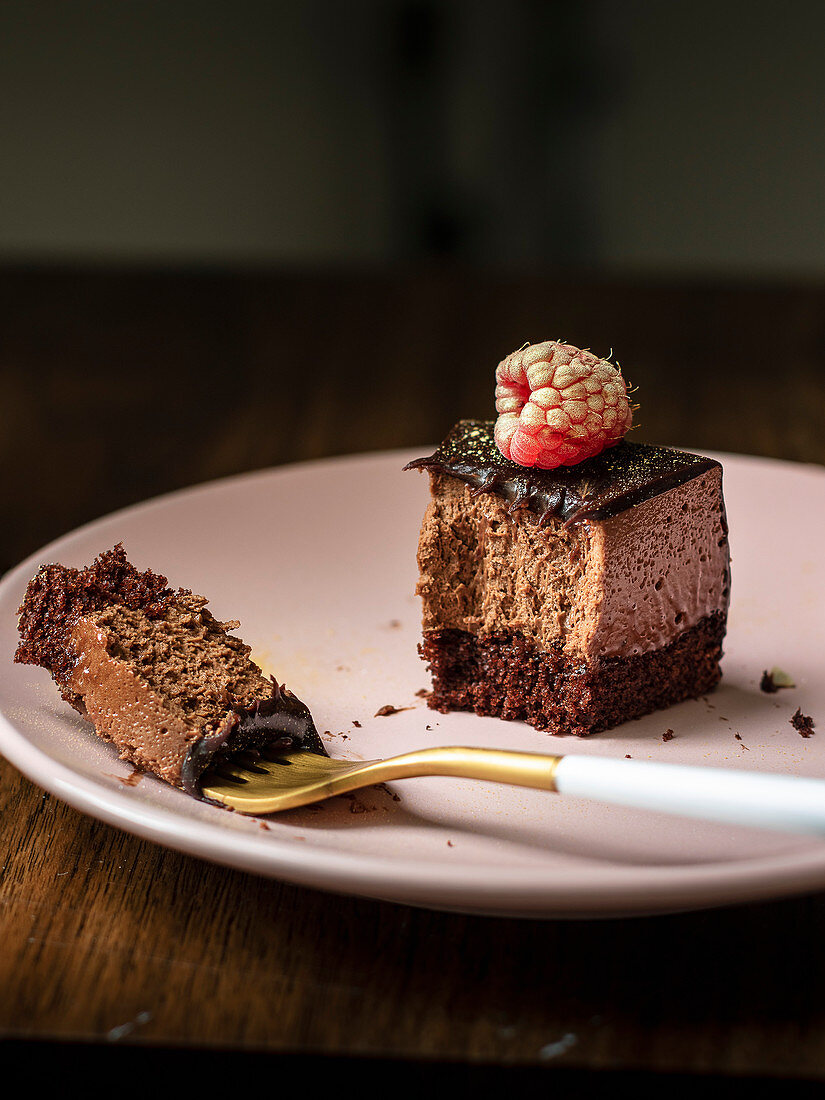 Chocolate truffle cake with raspberries and chocolate decoration on top on the plate