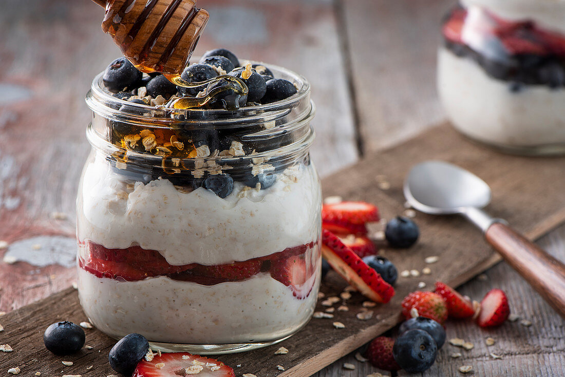 Yoghurt muesli with berries and honey in the glass
