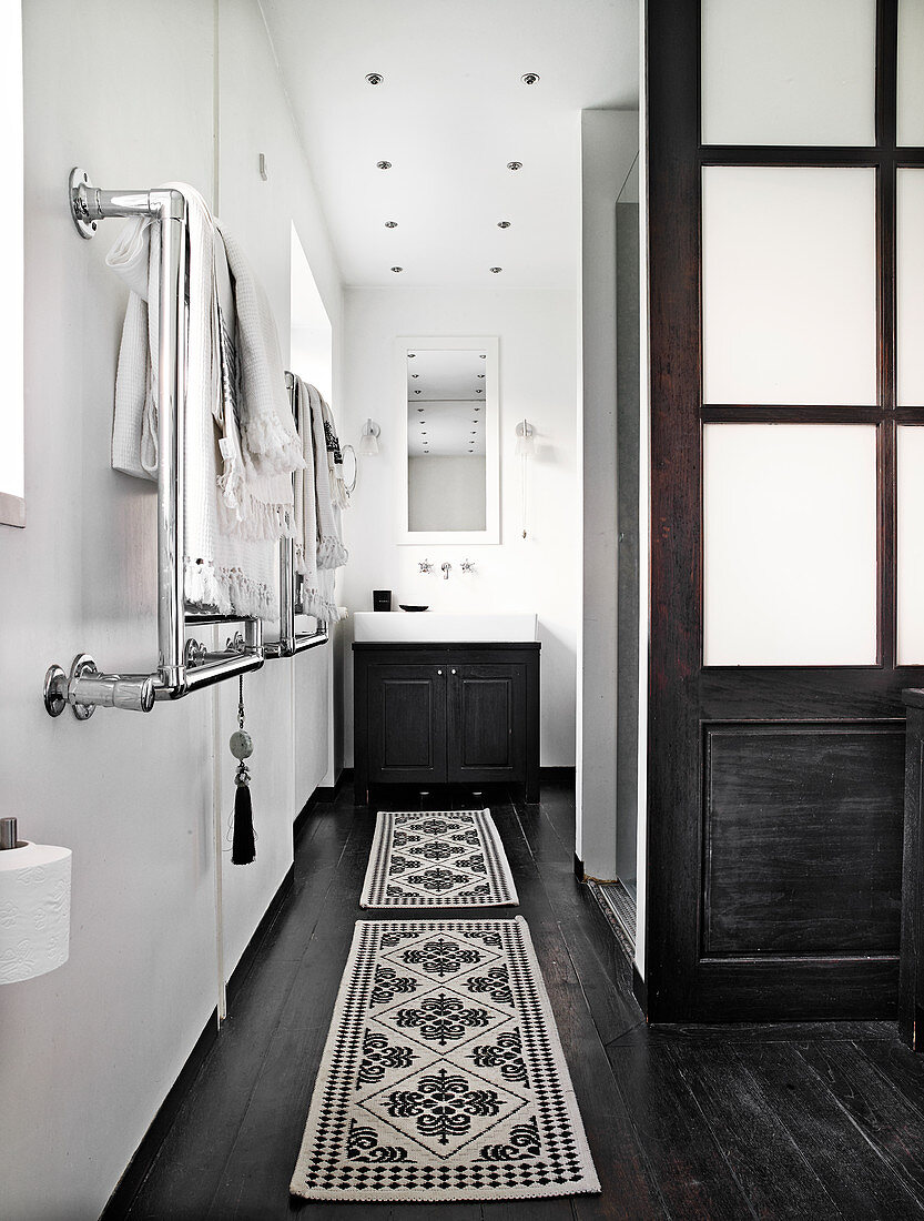 Vanity unit in the bathroom with white walls and black painted floorboards