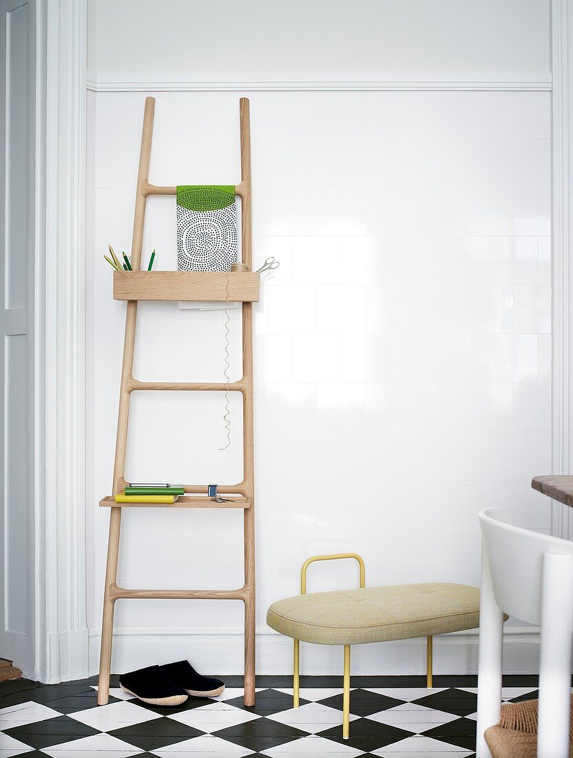 Ladder with shelf on the wall on checkered floor